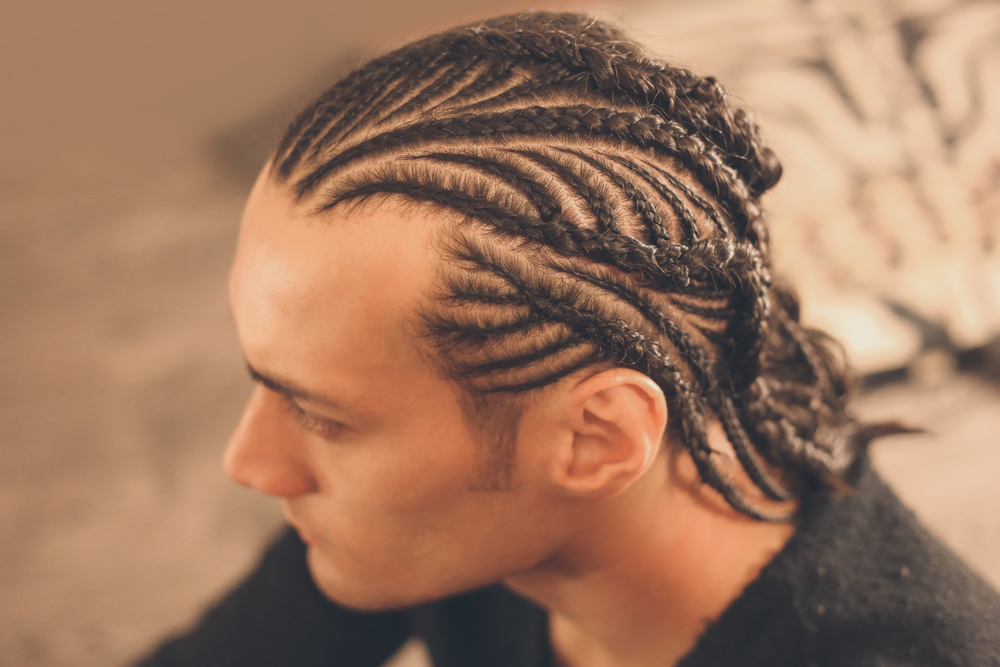 A featured white men's braided hairstyle on a man in a studio