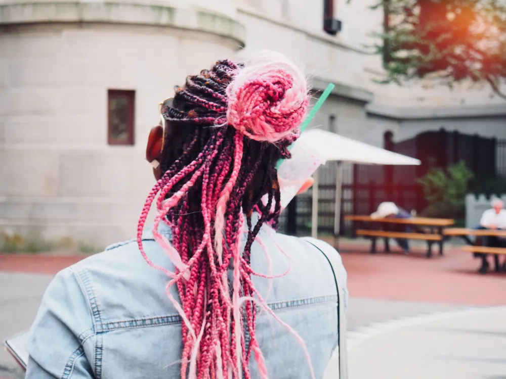 Woman with box braids looking at a building away from the reader for a piece titled can you get box braids wet