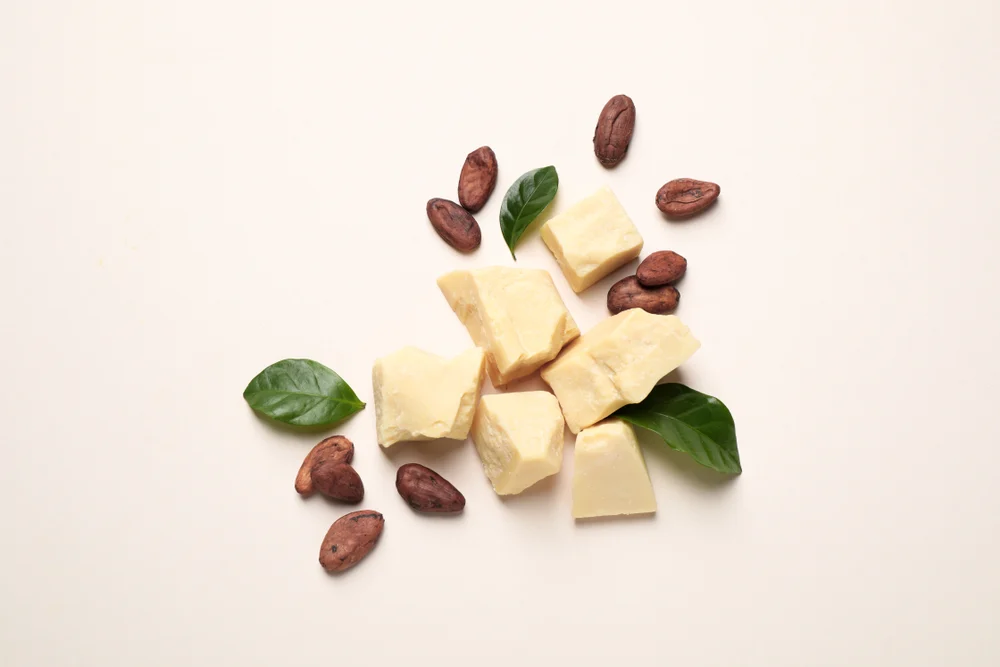 Image for a piece on is cocoa butter good for your hair with butter and beans on a taupe table