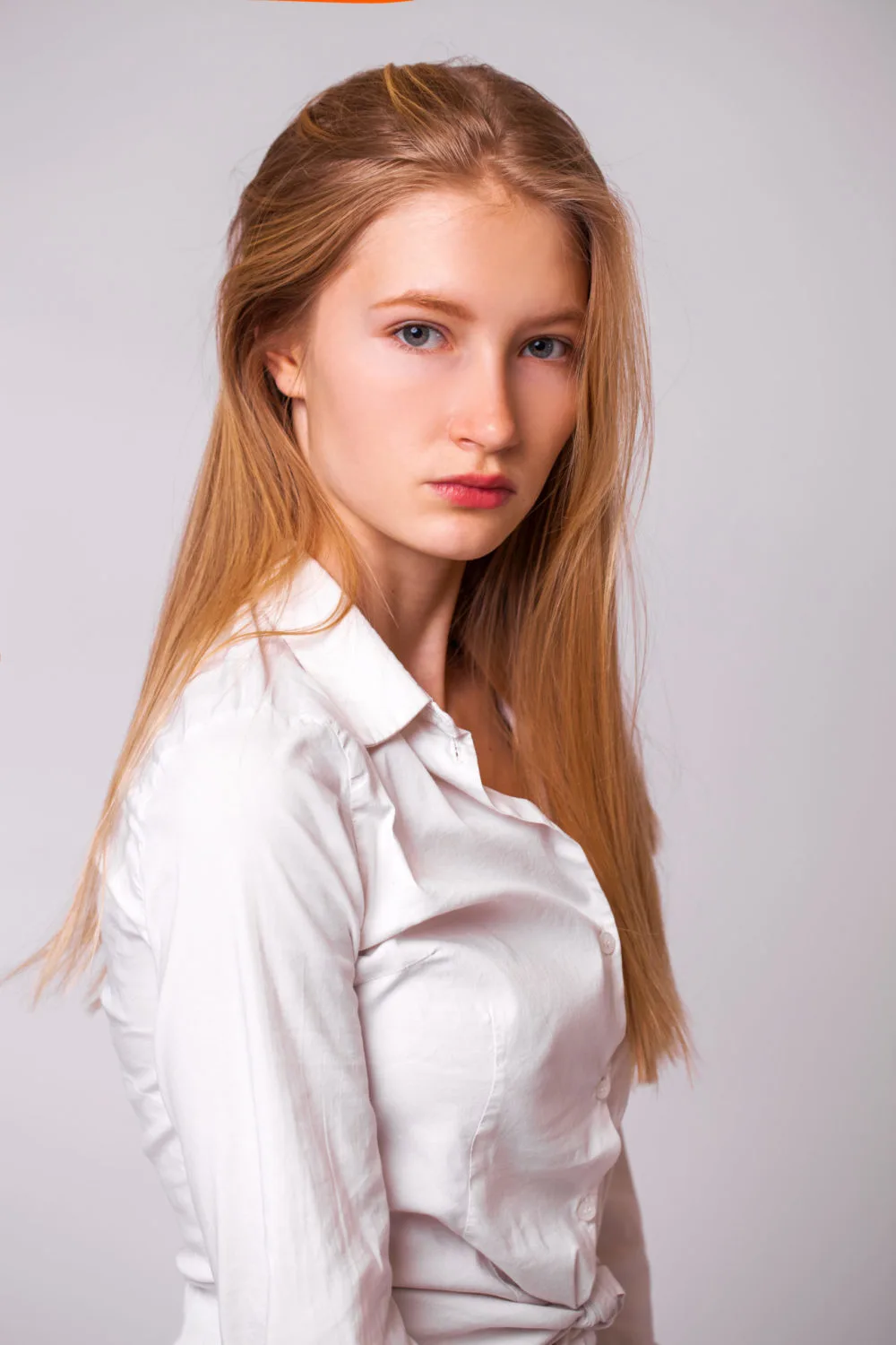 Dark Copper Blonde hair on a woman in a white button-up shirt