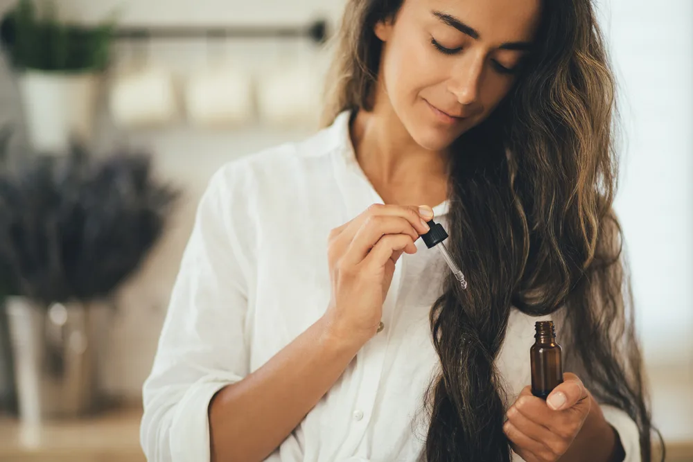 Woman applying pumpkin seed oil to her hair