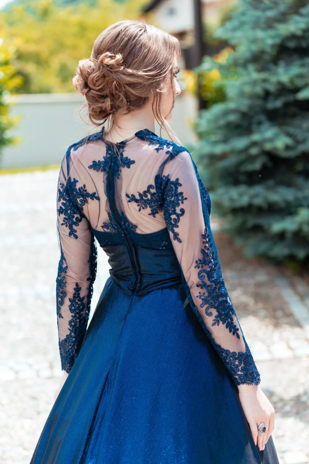 For a piece on prom hairstyles a woman in a blue dress wears a Twist-Back Low Pinned Curls