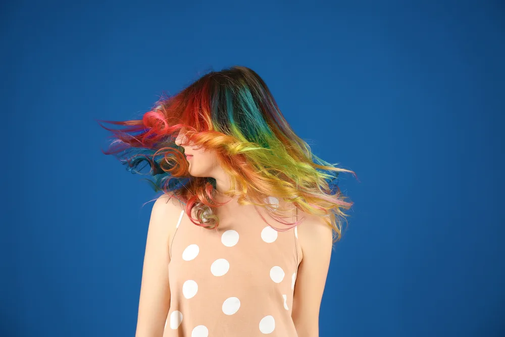Bold Rainbow Ombre hair on a woman in a tan polka dot dress