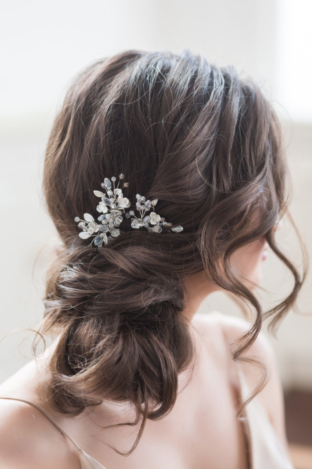 Loose Twisted Chignon With Floral Accents, a featured mother of the bride hairstyle