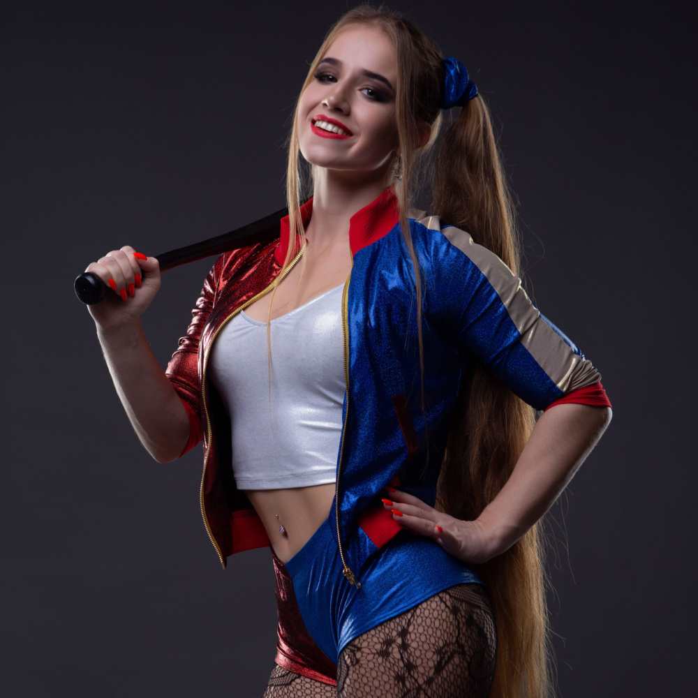 Woman dressed up as Harley Quinn to show off one of the best Halloween costumes for blondes featuring pigtails and a baseball bat