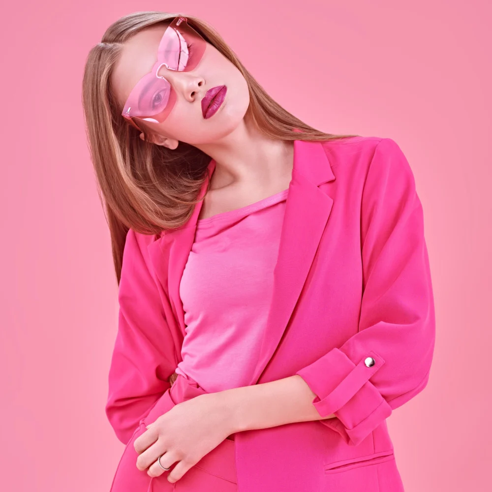 Woman dressed up as Elle Woods of Legally Blonde as one of the top Halloween costume ideas for blondes in pink suit and sunglasses