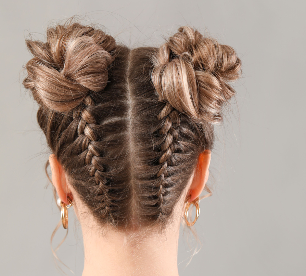 Back view of woman wearing a hairstyle for thin long hair featuring upside down braids and space buns