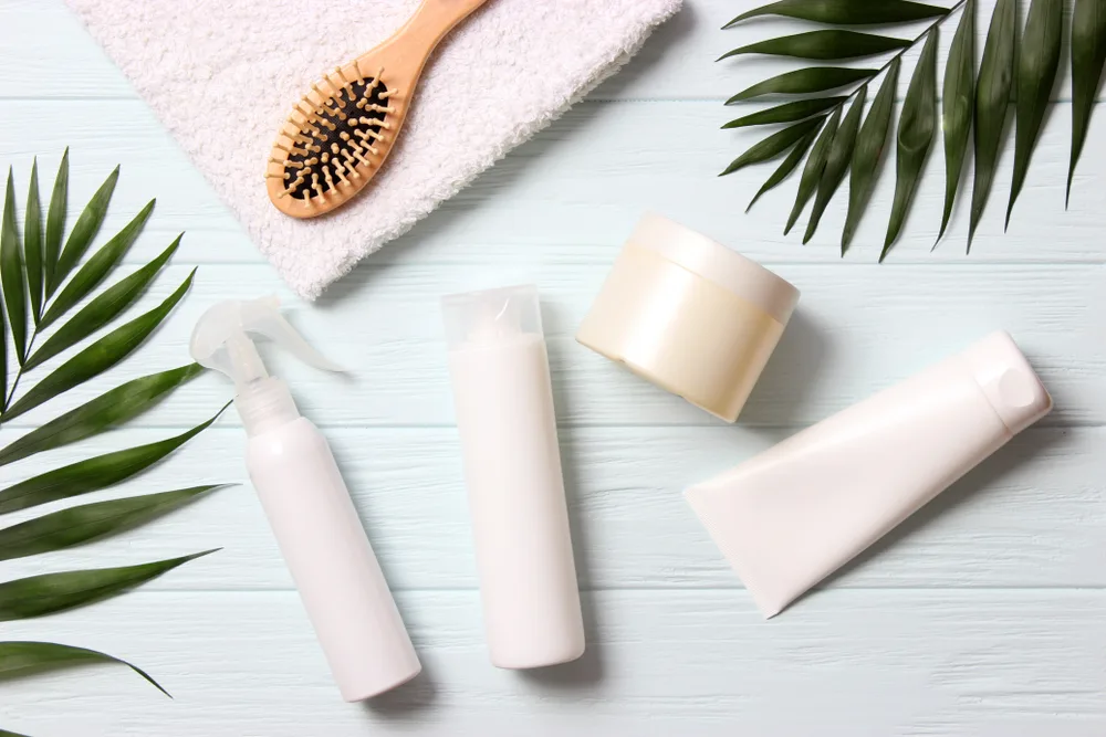 For a piece on the best wave shampoo, several bottles of hair products sit in a layflat image on a grey table
