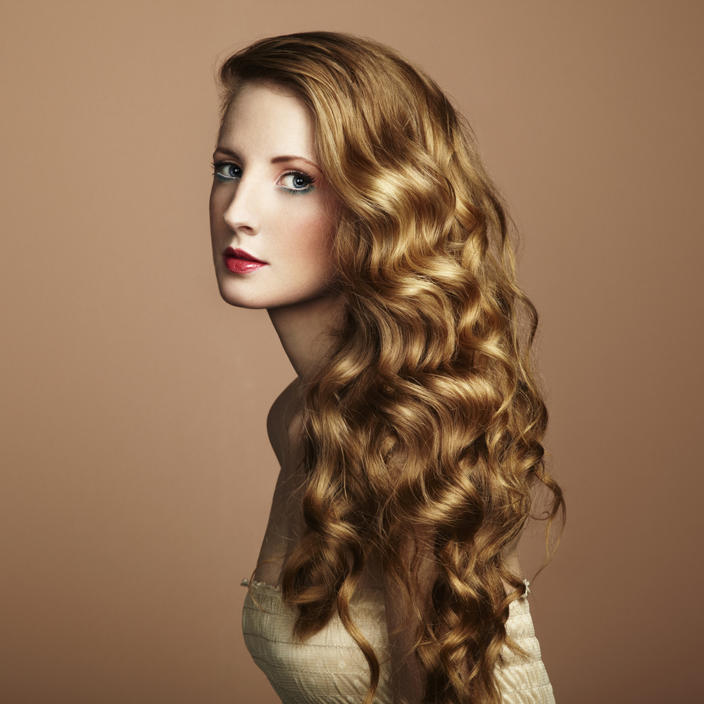 For a piece on the best hair colors for curly hair, a woman wears Dark Flaxen Blonde