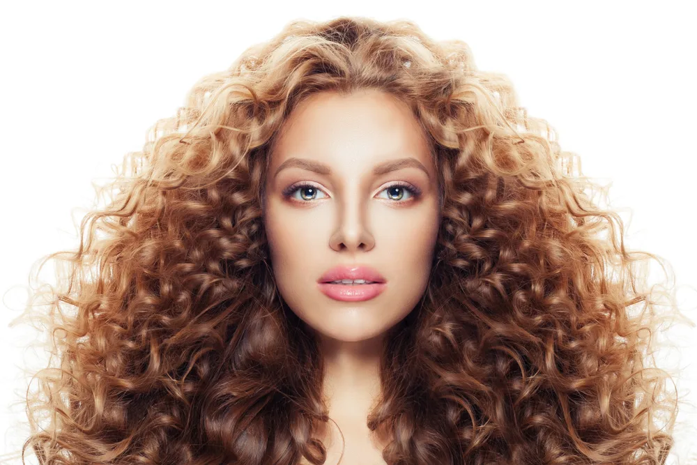 Golden Blonde Auburn Layered Ombre hair on a brunette woman for a piece on the best hair color for curly hair