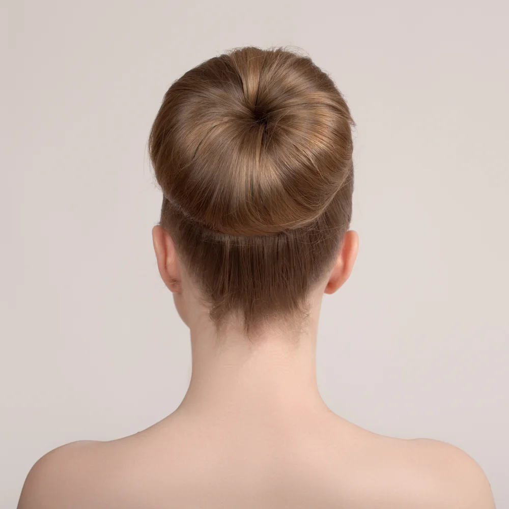 Rear view of woman with bare shoulders wearing a thick ballerina bun using a hair donut for long thin hair