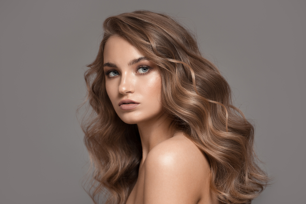 For a post on the best hair colors for medium skin, a woman wears Light Mocha With Face-Framing Highlights