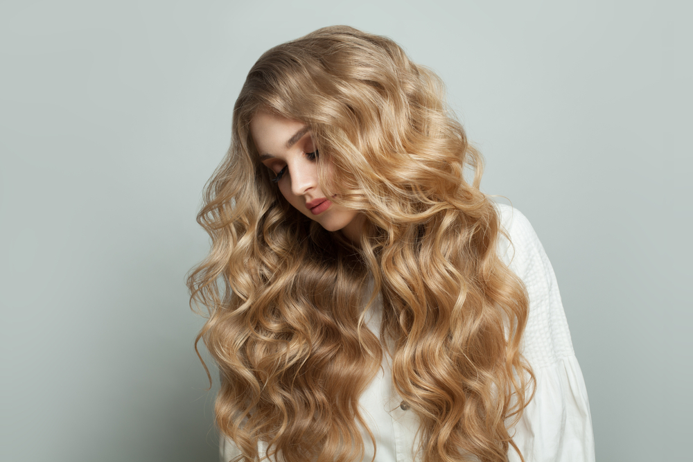 Woman with wavy hair wondering what the best curl enhancers for her hair are