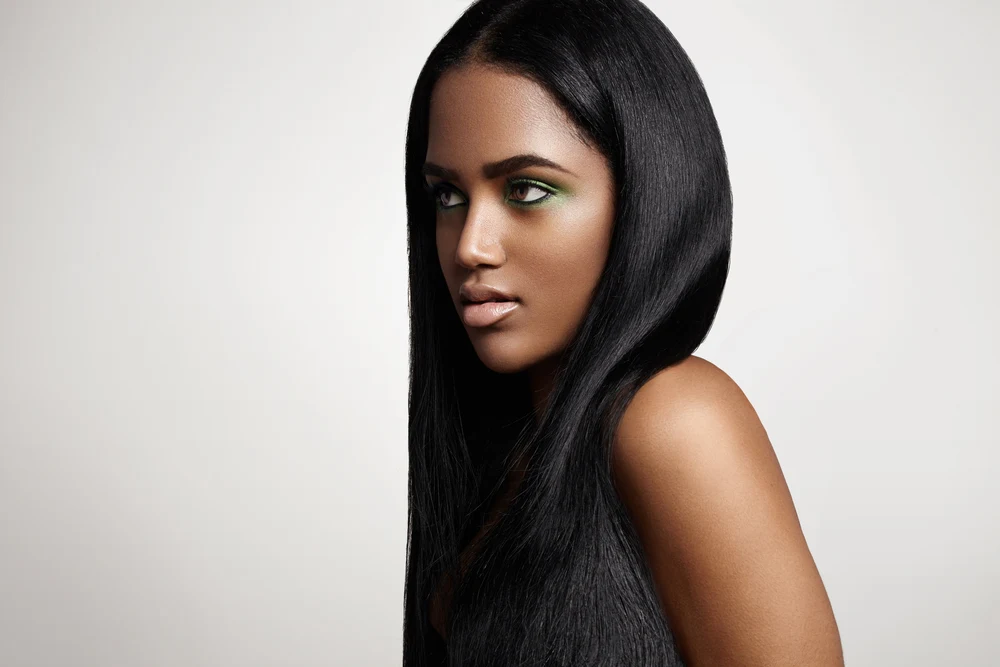For a roundup of the best hair colors for tan skin, a woman wears Sultry Jet Black