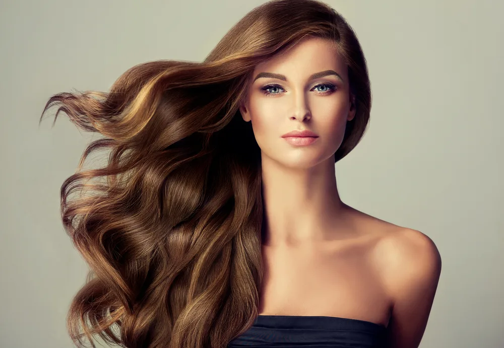 Light Golden Brown With Face-Framing Highlights, one of the best hair colors for tan skin