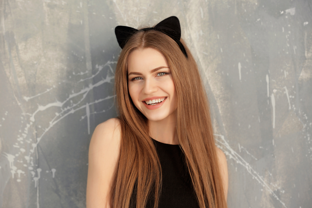 Woman smiling with dark strawberry blonde hair and cat ears