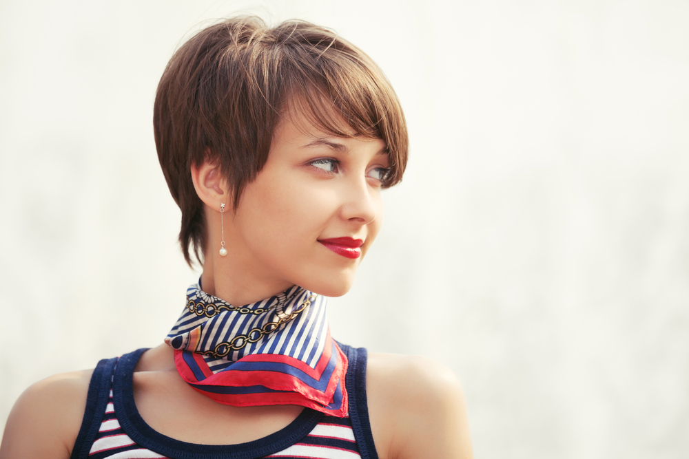 Woman glances to the side with patterned scarf and shows one of the best hair colors for short hair