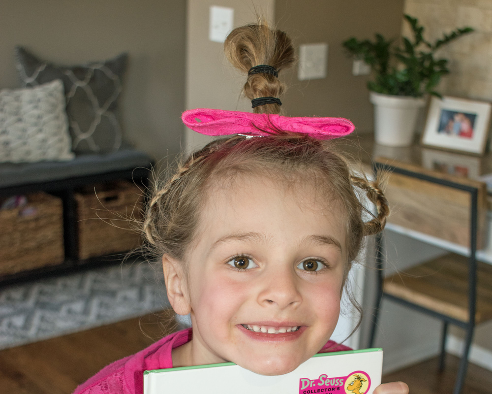 Little girl wears Cindy Lou Who hairstyle for crazy hair day with pink ribbon