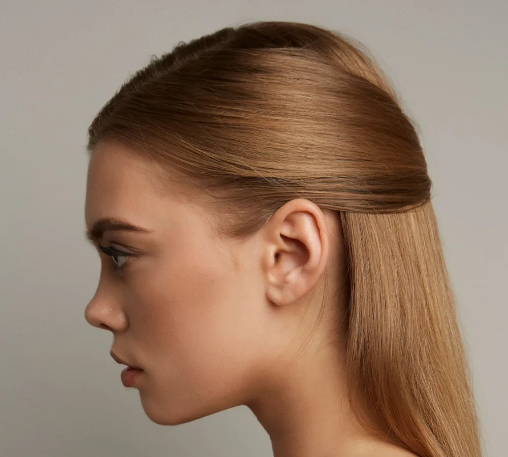 Serious woman side view with simple half up half down hairstyle on dark blonde hair