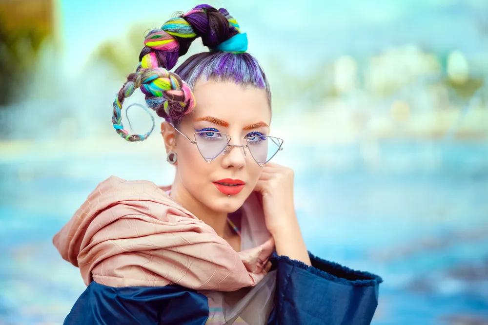 Young woman with glasses wears a colorful wacky rope braid as one of the best crazy hair day ideas
