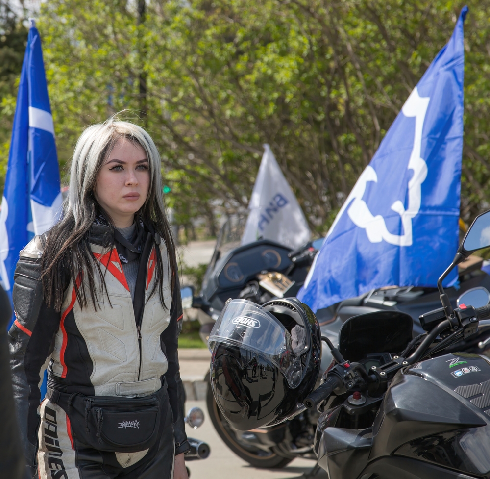 Platinum Blonde With Black Underdye hair color idea on a woman in a motocross suit