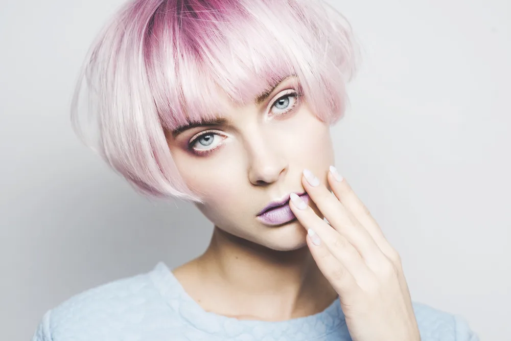 Fuchsia and Light Pastel Pink Ombre hair on a fair-skinned woman holding her left hand to her chin