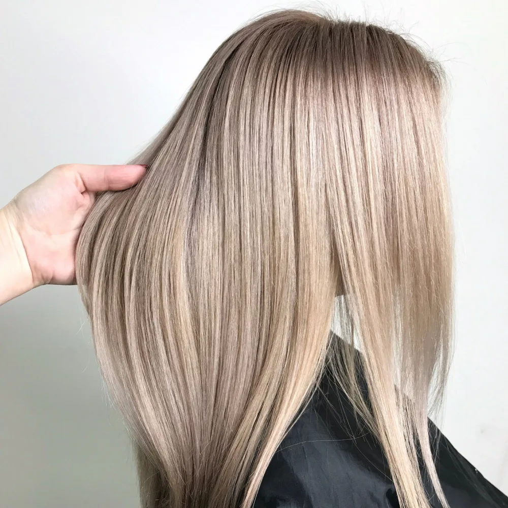 Side view of woman with golden dirty blonde shade in salon chair after dyeing