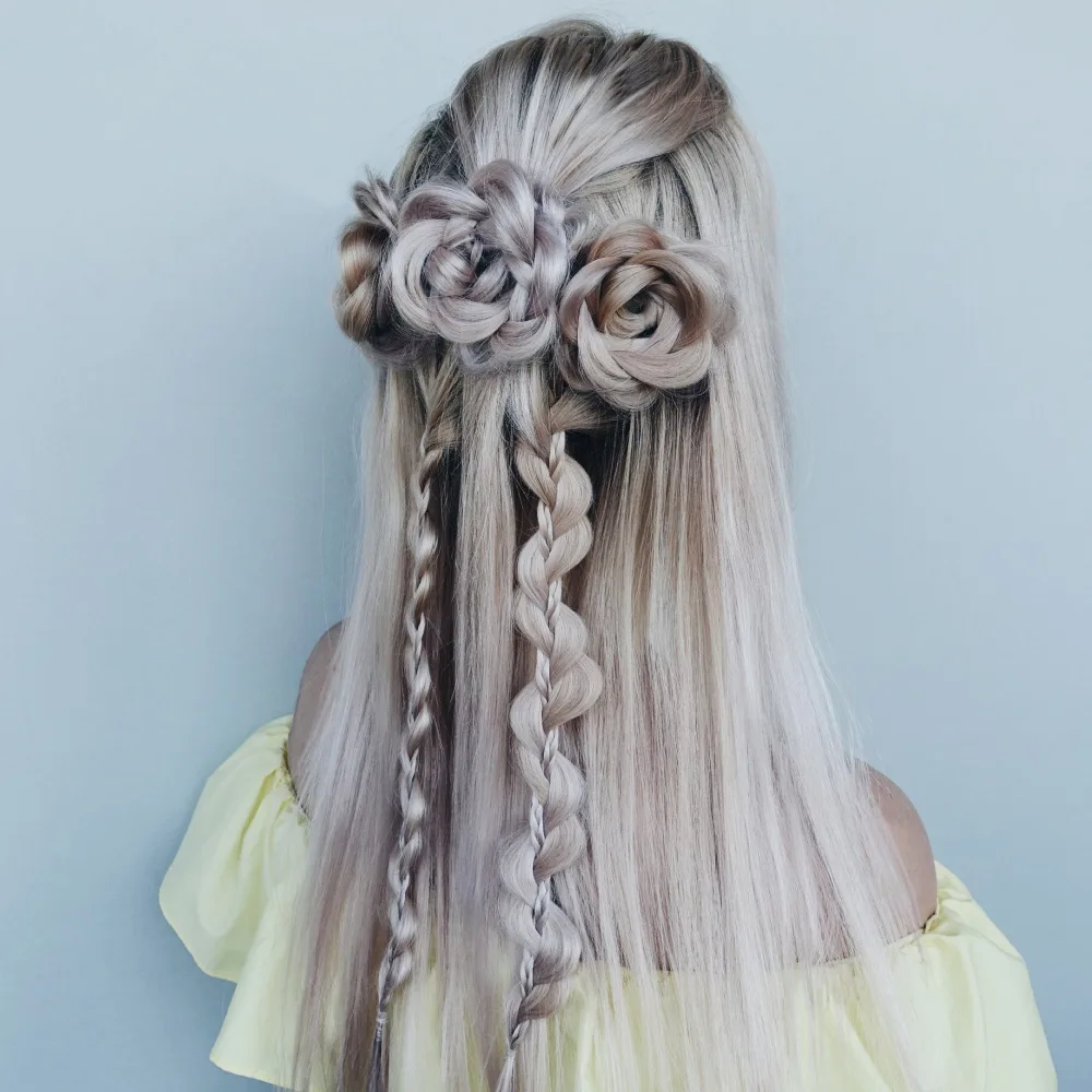 Young girl with blonde hair wears braided flowers as one of the top half up prom hairstyles for girls