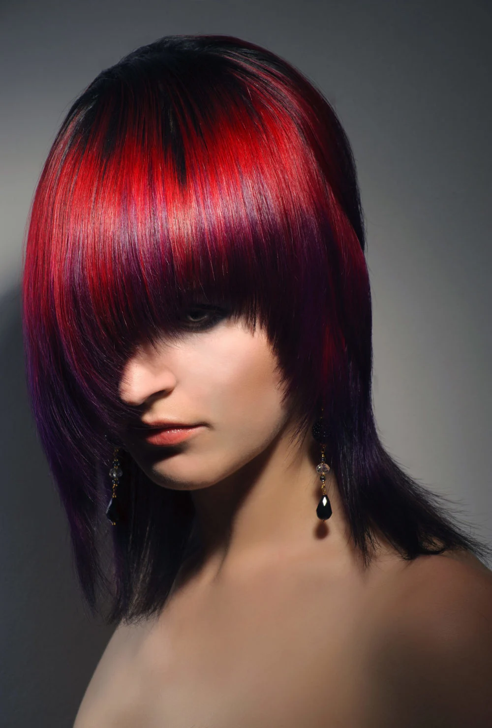Siren Red With Peekaboo True Violet Purple and Red Hair Color on a woman with bangs covering her eyes
