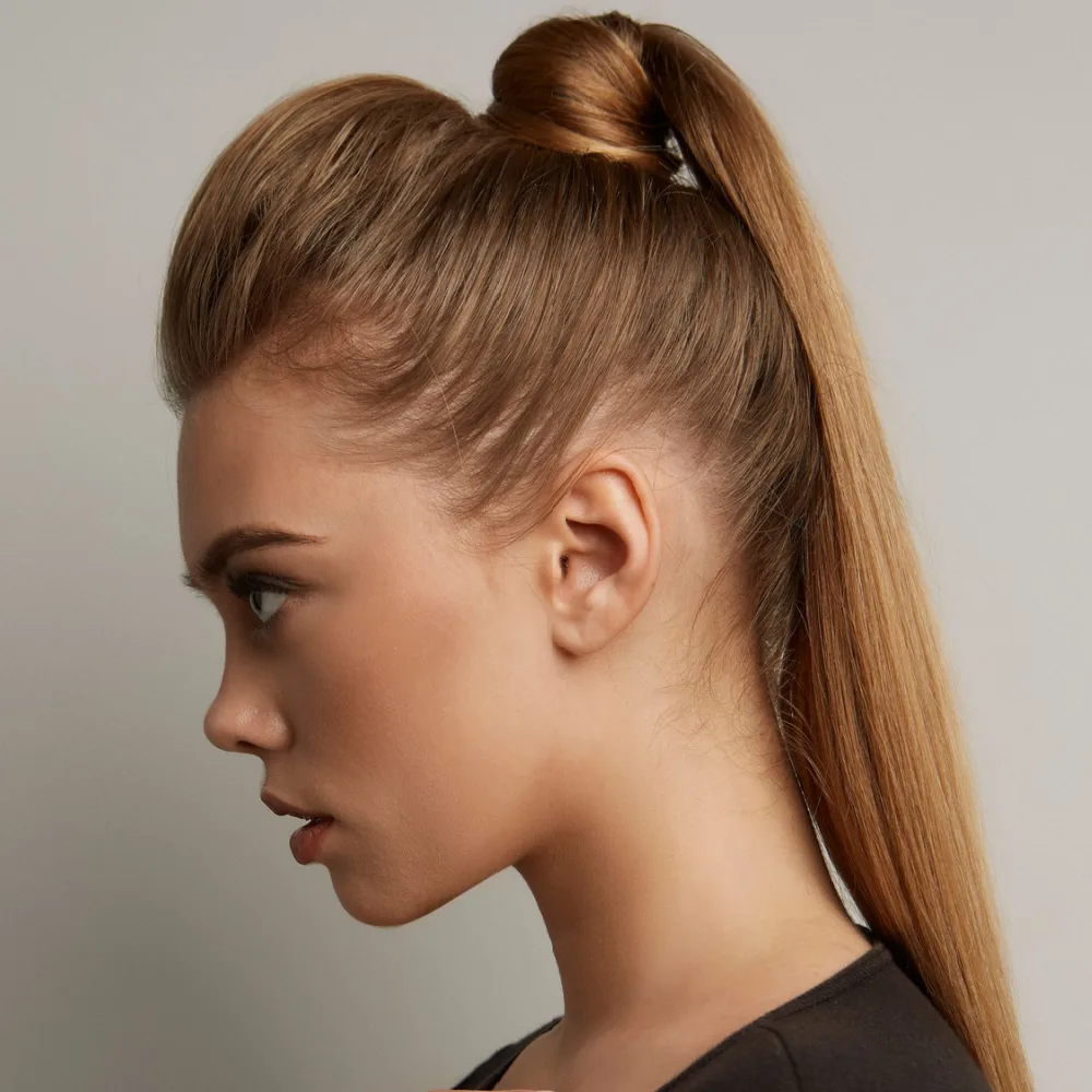 Side close-up view of woman in black shirt looking serious as she rocks one of the modern high ponytail hairstyles with a volume boost in front