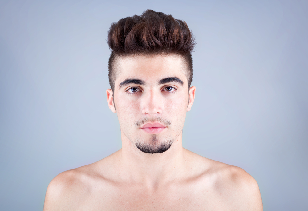 Close up of man with an undercut and pompadour, listed as one of the top low maintenance cuts for men