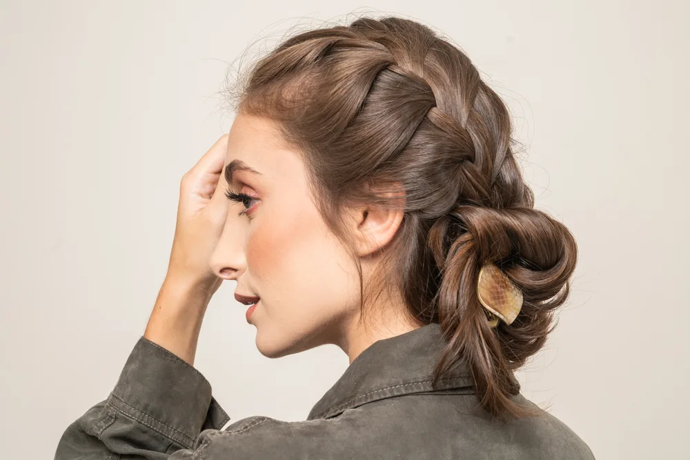Profile view of woman wearing double French braids and clipped buns to show the best hairstyles for long straight hair
