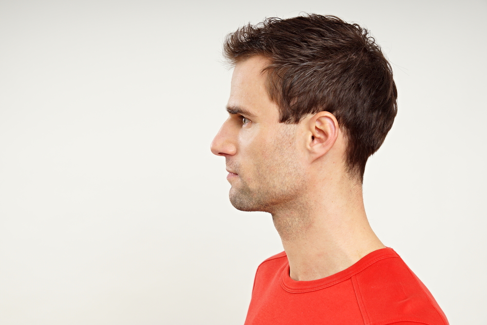 Side profile view of a man in a red shirt wearing a short tousled taper haircut that's considered low maintenance and easy to style