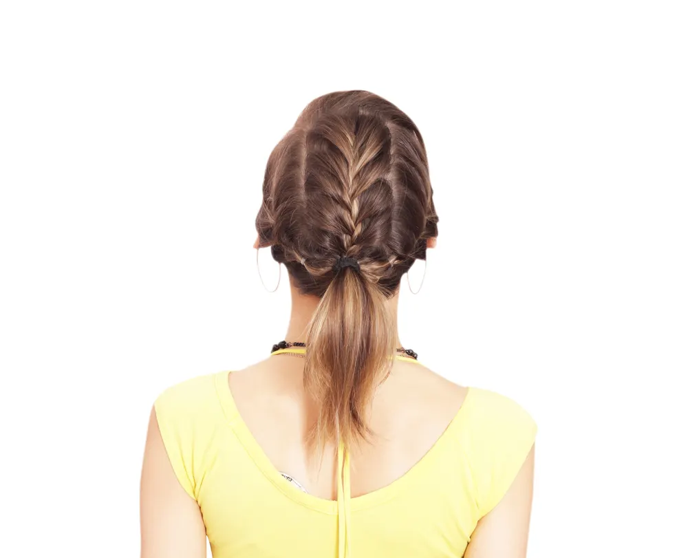Back view of woman with brown hair and yellow shirt wearing an example of braided ponytail hairstyles featuring 3 French braids
