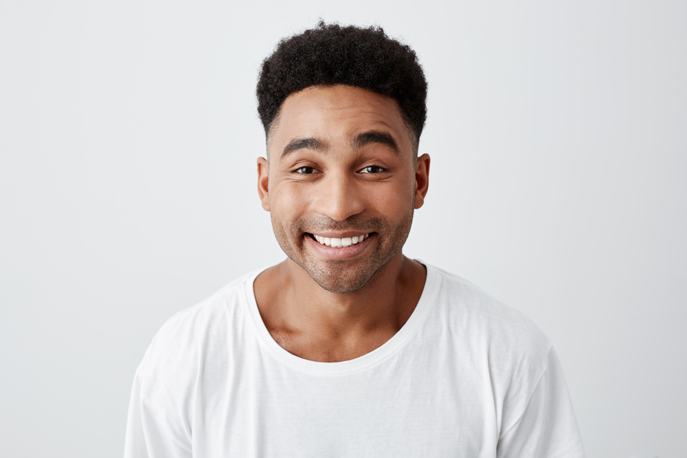 Young African American man wears a shaved undercut with afro on top as one of the top low maintenance haircuts for men
