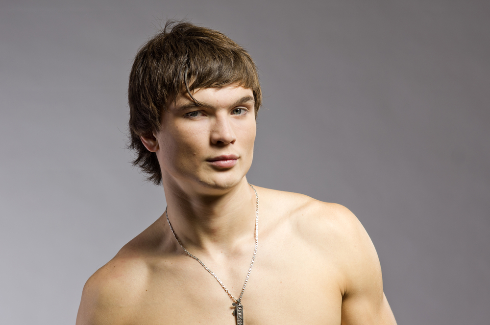 Shirtless young man has a mini mullet, one of the top low maintenance haircuts for men who like unique styles